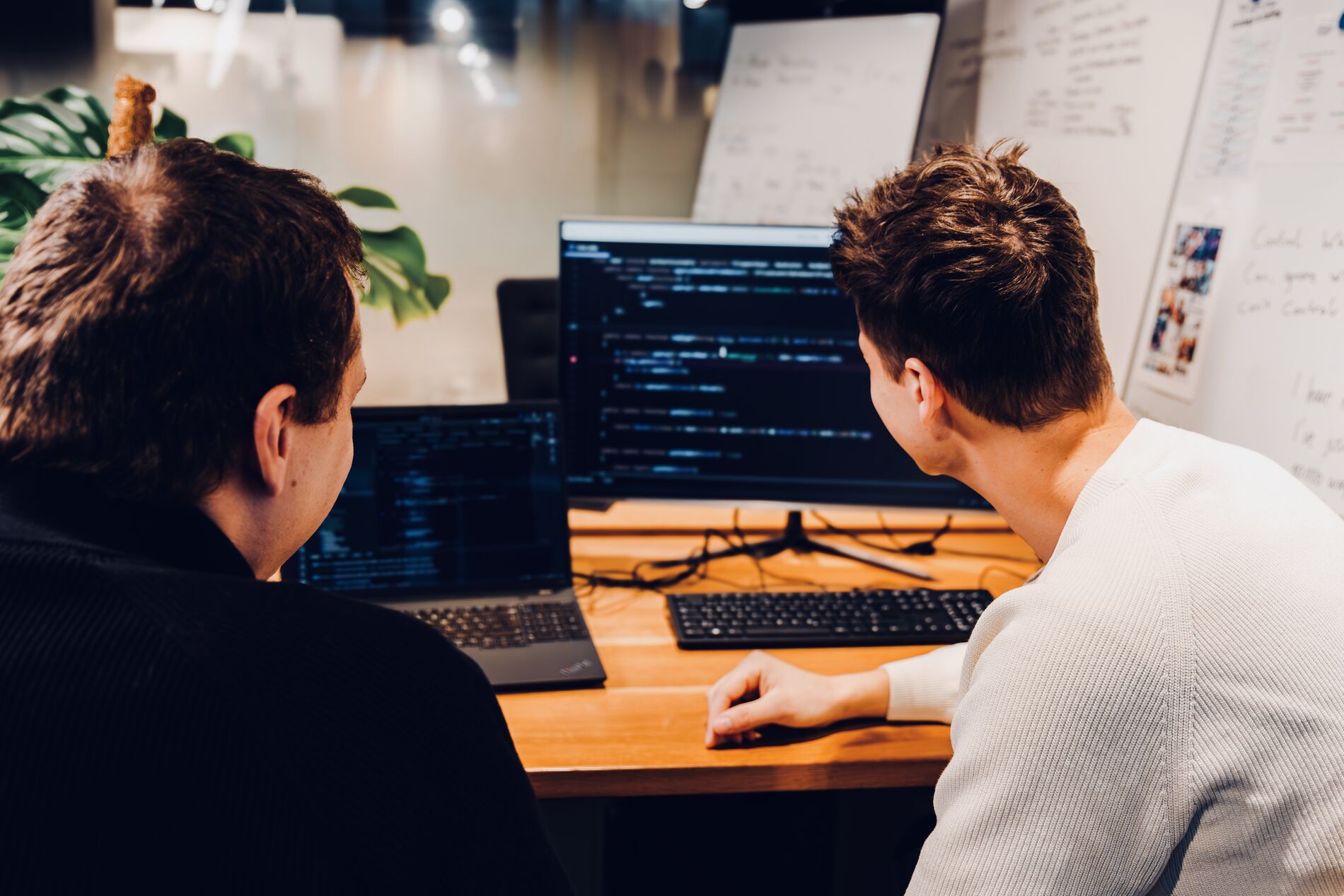 Das TDM-Team arbeitet gemeinsam an einem Schreibtisch im Büro.