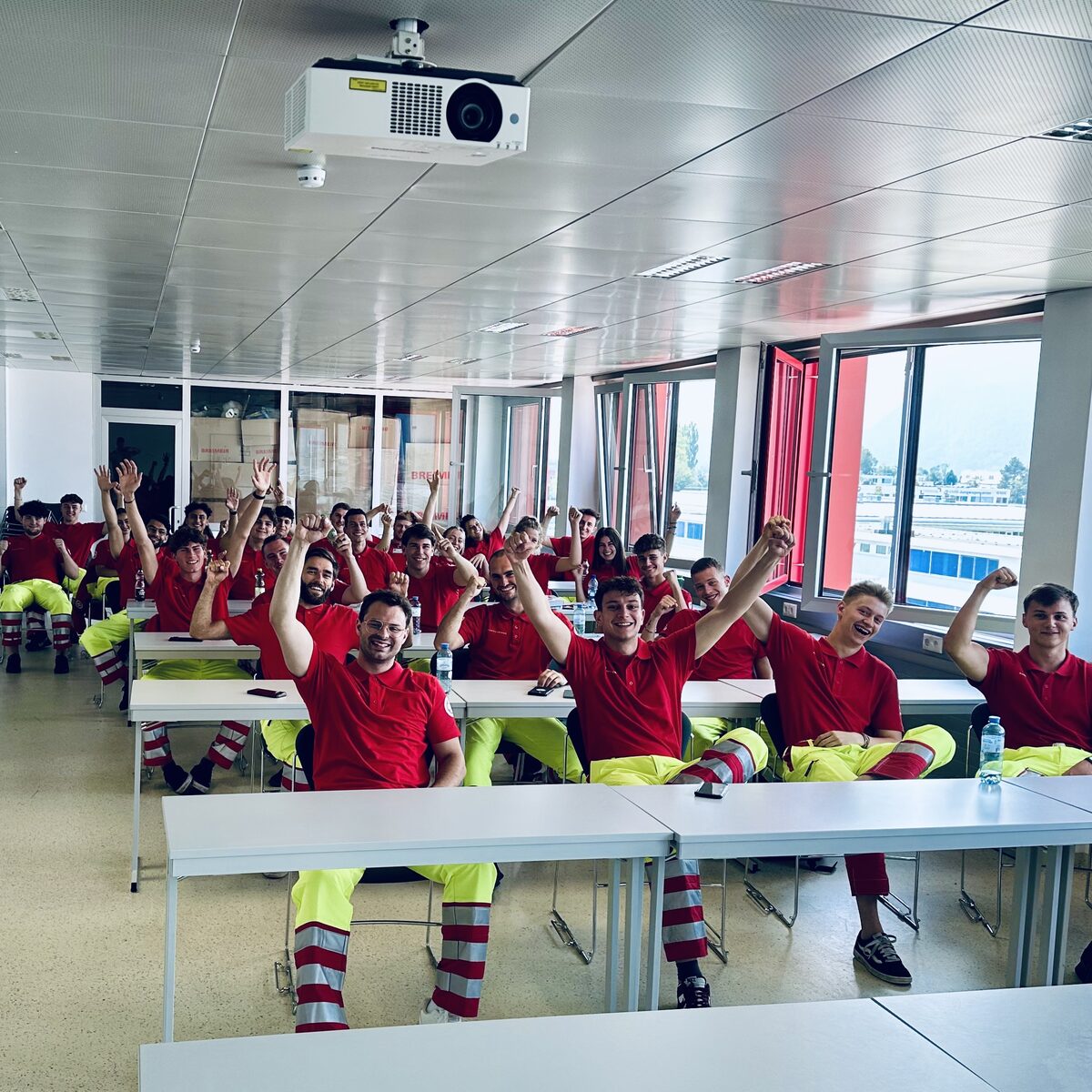 Eine Gruppe frisch geschulter Spendenwerber:innen jubelt gemeinsam im Seminarraum.